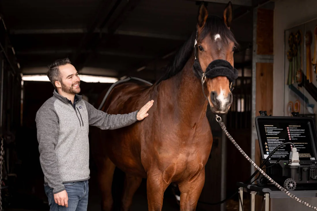 Pferd und Betreuer im Stall neben dem HIPPOFLOW-Gerät